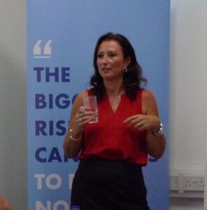 lady standing at the front of a room talking